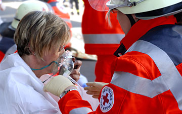 Foto: Ein DRK-Helfer versorgt eine Frau mit einer Sauerstoffmaske